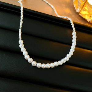 Détail d'un collier asymétrique en perles baroques et pépites d'argent sur cuir
