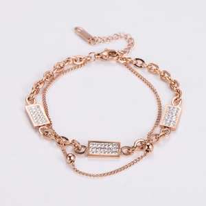 Detailed macro view of rose gold double-layer chain bracelet with sparkling crystal accents