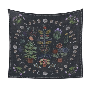 Detail of bohemian quilted tapestry featuring celestial moon phases and floral patterns