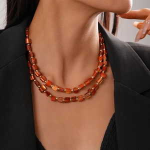 Double-layered red beaded necklace with irregular faux shell tiles and gold accents