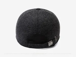 Detailansicht der Metallschnalle und der dunkelgrauen Stricktextur dieser Wintermütze