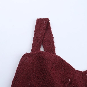 Détail de la robe de soirée rouge vin en tweed à paillettes montrant la texture du tissu