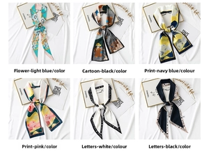 Close-up of printed long skinny scarves in floral and letter patterns with silk texture