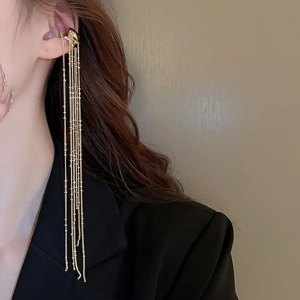 Detail showing long gold tassel ear cuff with multi-chain dangles on a model's ear