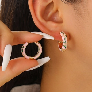 Vintage gold-plated hoop earrings with pink enamel floral patterns and white flower accents