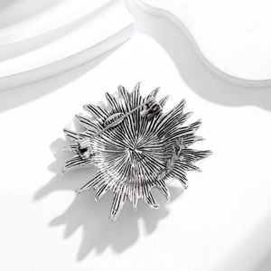 Elegant Sun Goddess sunburst brooch in vintage silver plating shown with back pin detail