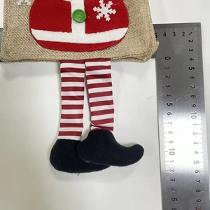 Dettaglio del sacchetto regalo di Natale in iuta con gambe lunghe a righe e decorazioni