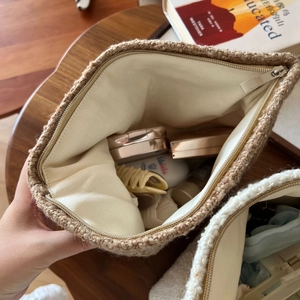 Macro shot of large capacity woven wool cosmetic bag with metal zipper and linen lining