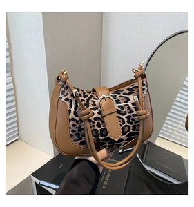 Detail of leopard print handbag with a unique knotted brown leather shoulder strap design