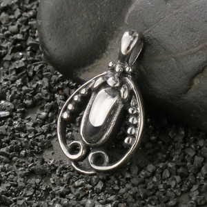 Macro shot of vintage silver pendant with ornate texture on dark stones