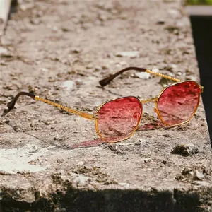 Chic hexagonal metal sunglasses with gold braided temples and pink gradient lenses