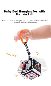 Detail of baby fabric book with high-contrast patterns and orange hanging ring for cribs