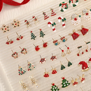 Christmas earring set with festive motifs like reindeer and tree on stripe board
