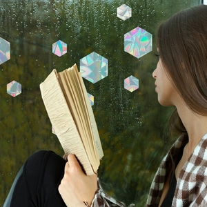 Close-up of holographic hexagonal window film creating colorful prism effects on glass