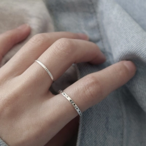Detailed view of 925 sterling silver star ring and textured band on denim background
