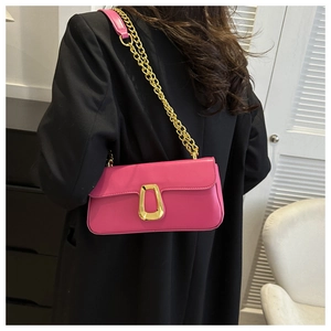 Rose red shoulder bag with gold chain strap and buckle shown on person from behind