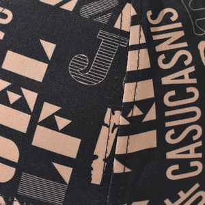 Close-up detail of durable black canvas baseball cap fabric with beige graffiti print
