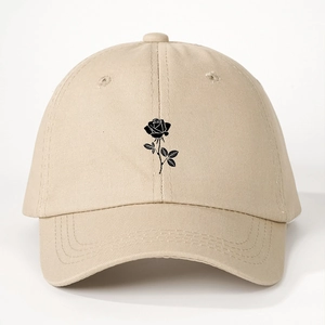 Detailed view of black rose embroidery on a beige cotton twill baseball cap