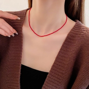 Collier élégant en perles de cristal rouge porté par un mannequin au cou