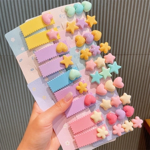 Macro shot of assorted macaron-colored hair clips in star, heart and flower shapes