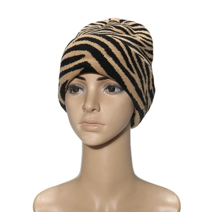 Detailed close-up of zebra stripe knitted beanie texture with black and yellow patterns