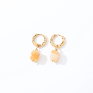 Macro detail of geometric gold hoop earrings with translucent square stone pendants