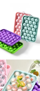 Detailed view of silicone ice ball molds with fruit pieces inside round ice spheres