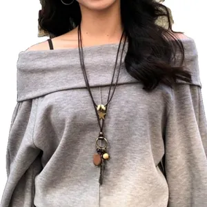 Bohemian ethnic long necklace with star and feather charms on female model in grey