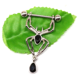 Bijou de piercing téton araignée argentée avec gemmes noires sur une feuille verte