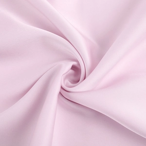 Detail of light pink satin fabric with a silky texture and soft drape for evening dresses