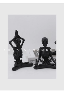 Détail de deux figurines de yoga squelette en résine noire en poses de méditation et namaste