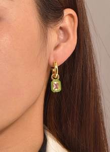Dettaglio di orecchini ottagonali dorati con zircone rosa e finitura in smalto verde