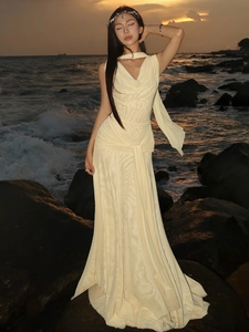 Elegant halter neck backless beige evening maxi dress with long scarf detail by the sea