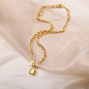 Detail of vintage 18k gold plated stainless steel necklace with padlock pendant on silk