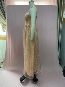 Détail de la robe maxi dorée à paillettes avec fines bretelles et couches de tulle