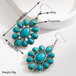 Boucles d'oreilles pendantes bohèmes en turquoise et alliage sur un plateau en pierre