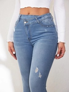 Detail einer hellblauen High-Waist-Jeans mit einzigartigem asymmetrischem Knopfverschluss