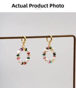 Detailed macro view of colorful beaded ring earrings with white pearls and gold accents