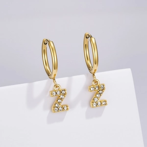 Golden letter Z earring with sparkling white zircons on a minimal white stand