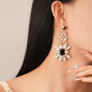 Macro shot of long flower drop earrings with black crystals and sparkling diamonds