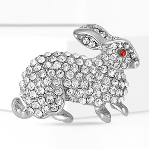 Macro detail of silver rabbit brooch with sparkling rhinestones and red crystal eye