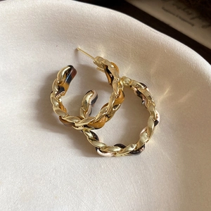 Detailed view of leopard print fabric intertwined with golden twisted chain earrings