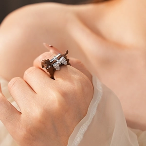 Detail of dachshund ring featuring a silver rhinestone bow on polished dark brown body