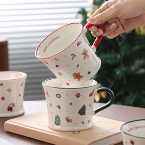 Close-up of ceramic Christmas mugs with gingerbread and reindeer festive patterns