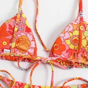 Detail of floral bikini top with neck ties and size S label on vintage print fabric