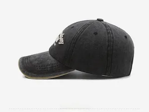 Detail of grey washed denim baseball cap with side embroidery and brown contrast piping