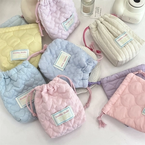 Flat lay of colorful quilted drawstring storage bags in various pastel colors and patterns