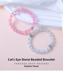Detailed macro view of pink and white cat eye bead bracelets with silver butterfly charms