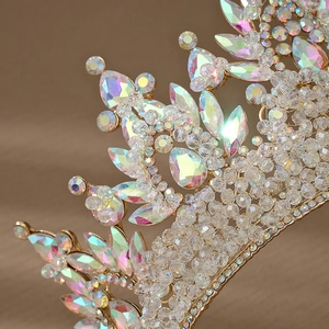Macro detail of luxury golden baroque crown with iridescent pink rhinestones