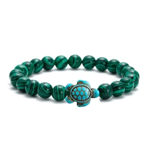 Close-up of green malachite texture beads and blue sea turtle charm on elastic bracelet